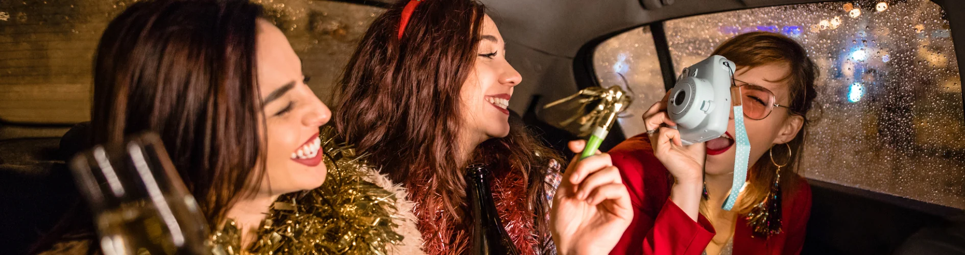 3 osoby siedzące w taksówce